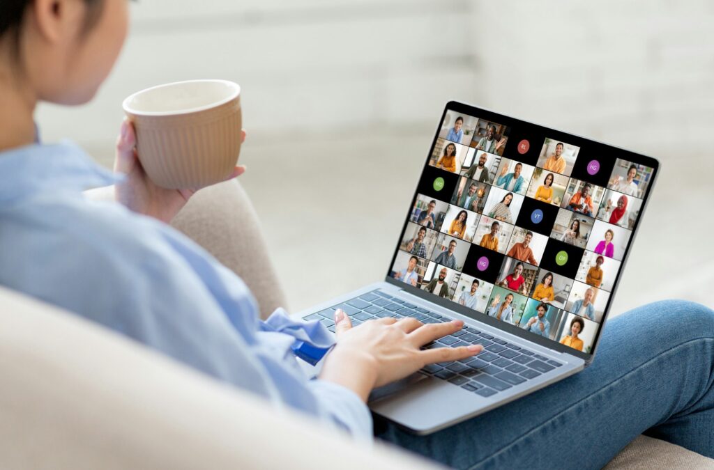 Woman Sitting on Couch Using Laptop for Online Video Conference